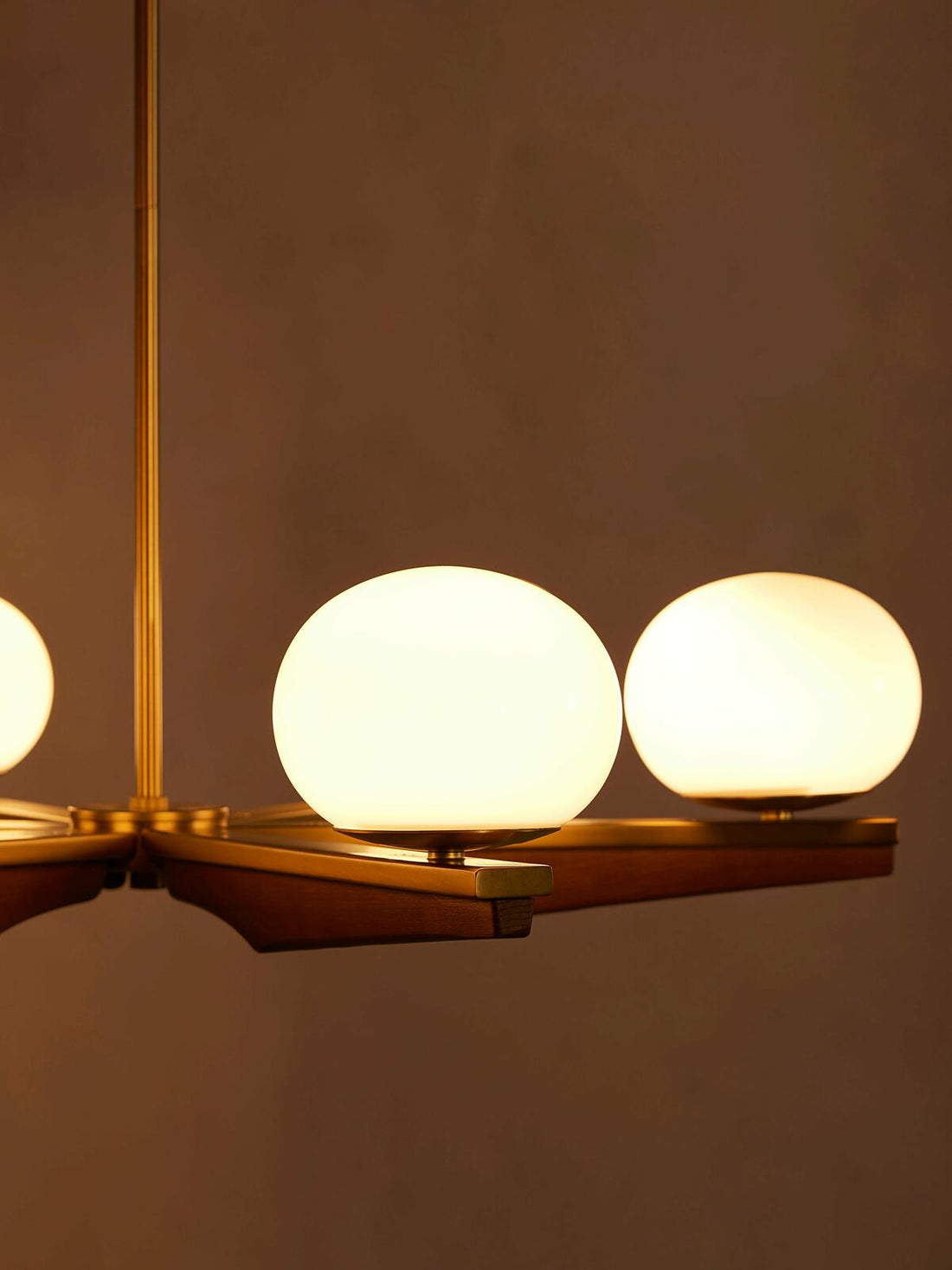 Demarco chandelier by Soho Home. Antique brass details, chandelier features six oval glass orbs, solid oak. Mid century inspired. Inspired by Soho House.