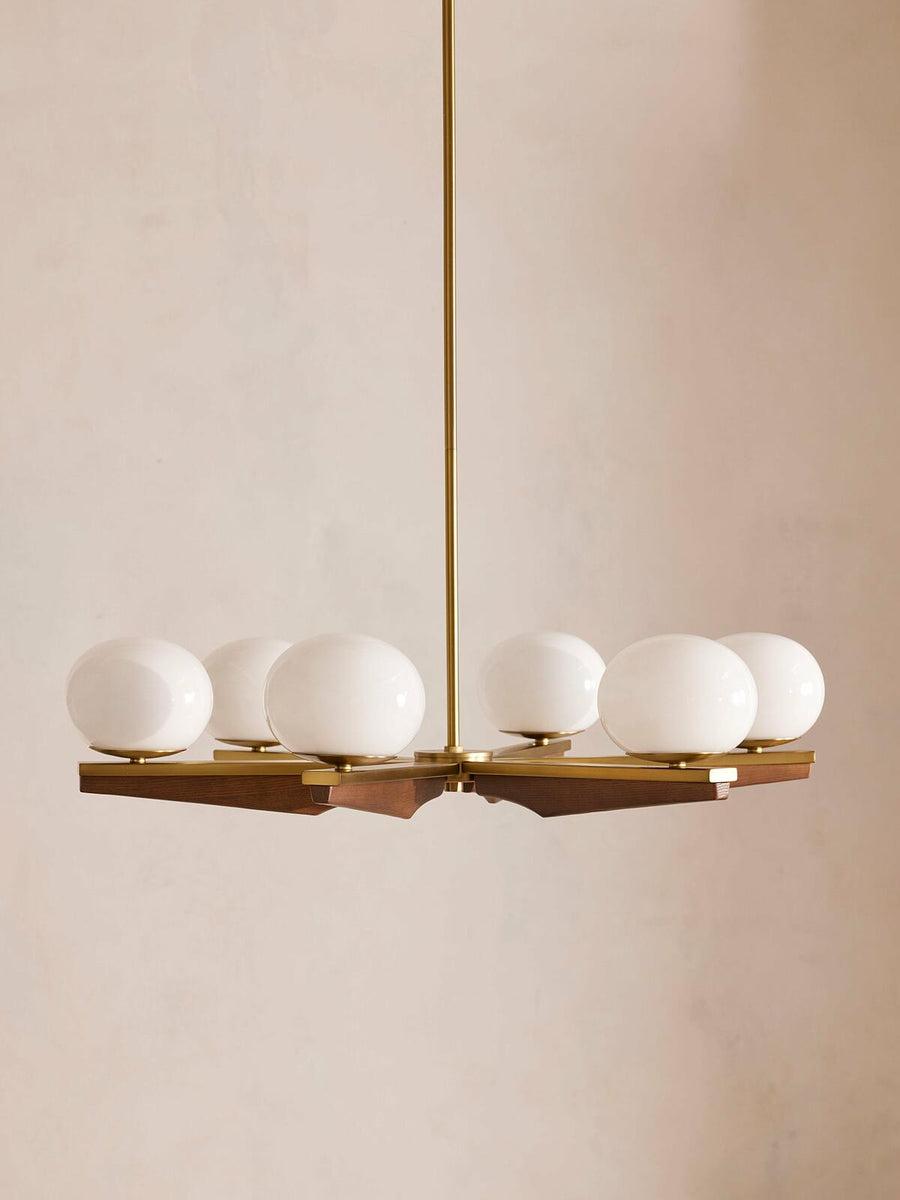 Demarco chandelier by Soho Home. Antique brass details, chandelier features six oval glass orbs, solid oak. Mid century inspired. Inspired by Soho House.